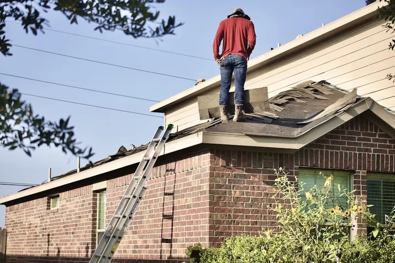Professional roofer working on a residential roof in Drexel Hill Center